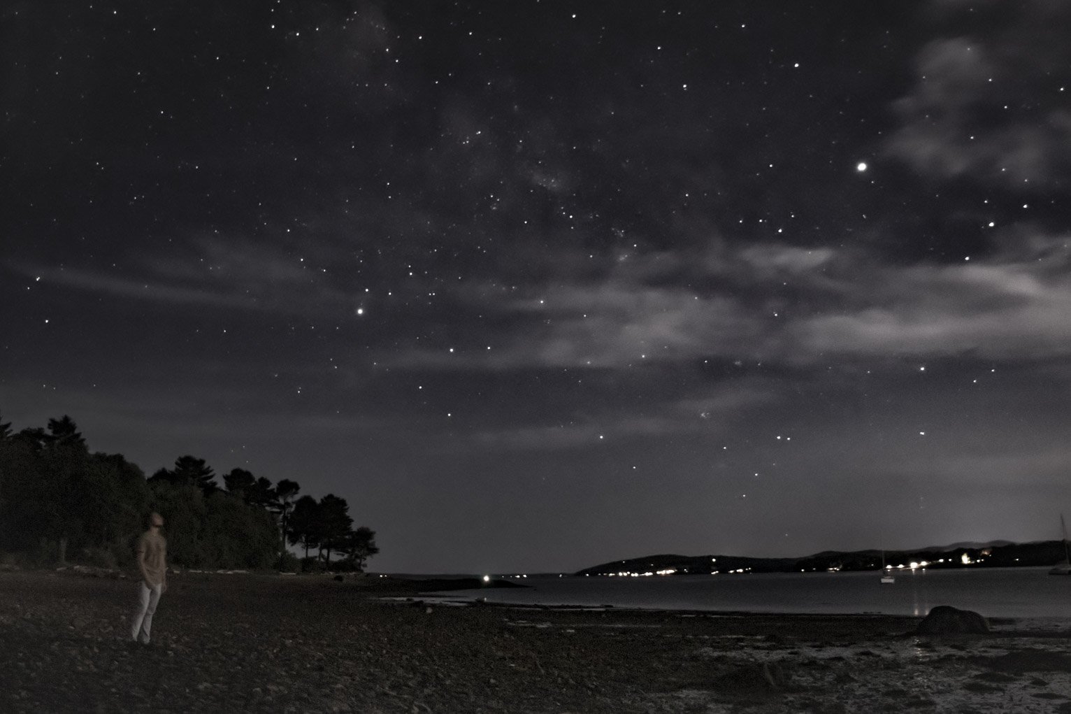 alguien mira hacia el cielo mientras camina en la orilla de una bahía